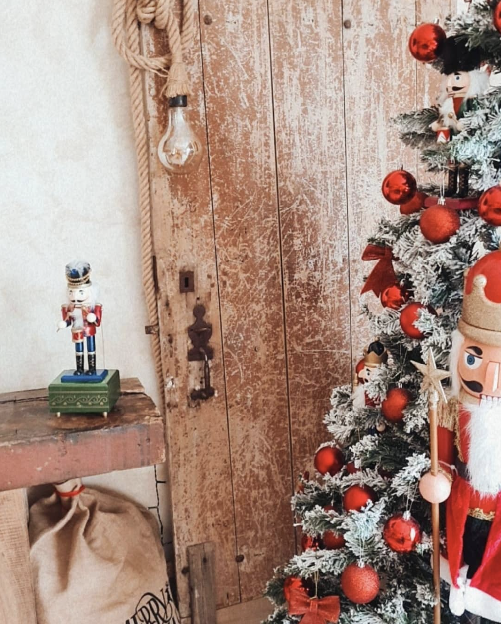 Detalhe festivo com árvore de Natal, madeira rústica e ornamentos vermelhos
